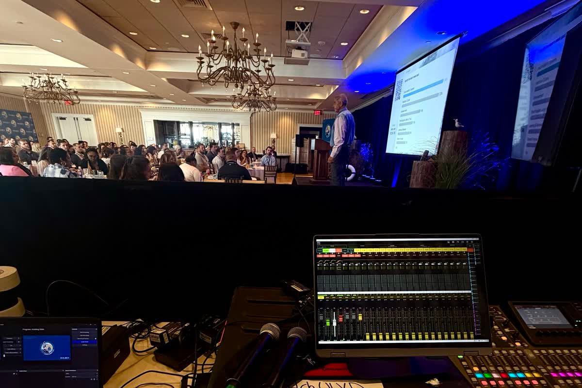 A full banquet room during a conference session, with the mixing console in the foreground